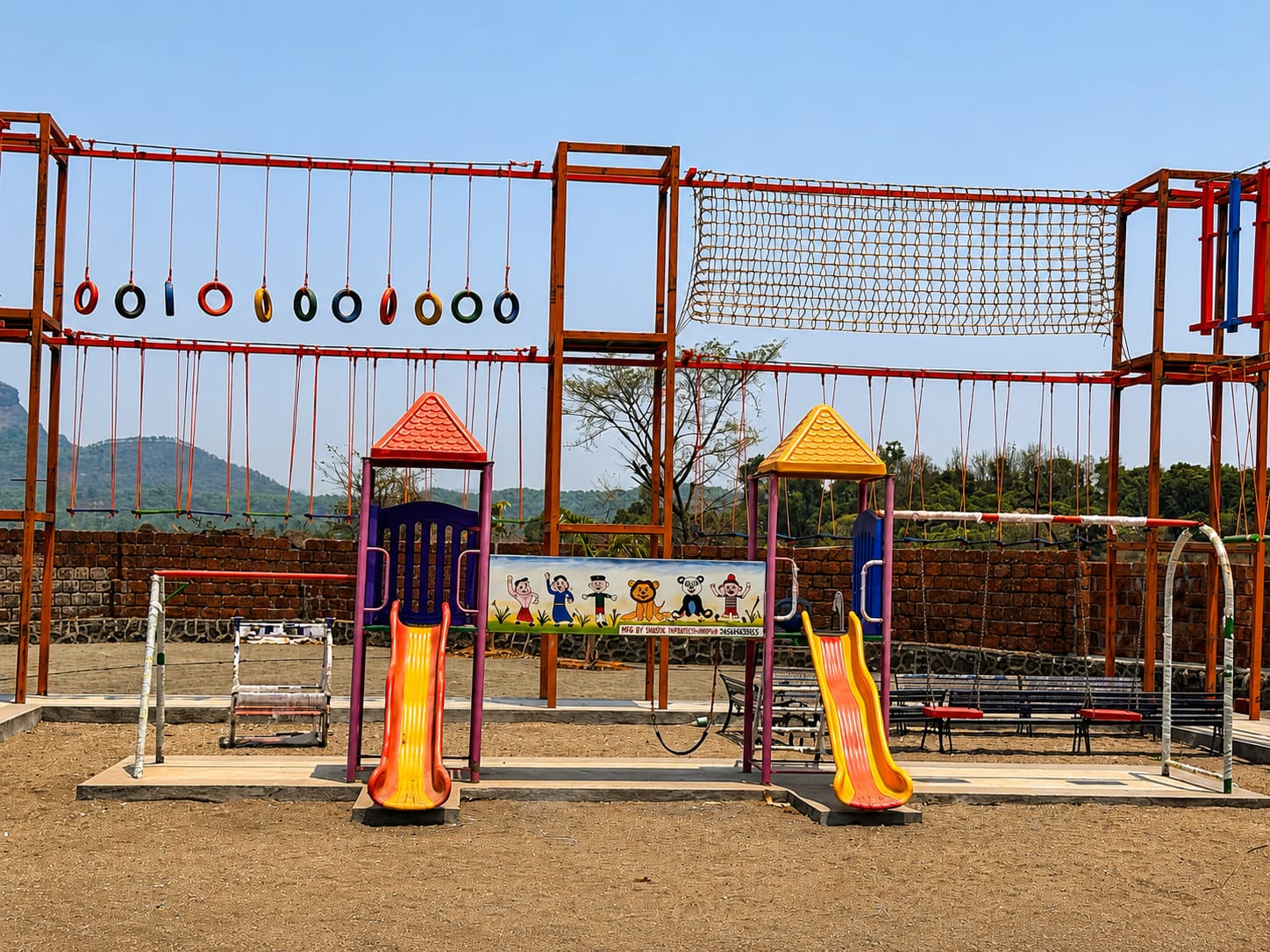 The kids’ play area: swings, gymnastic rings, a climbing net and two slides on the open ground